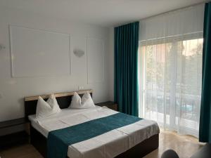 a bedroom with a bed and a large window at Vila Sofia in Eforie Nord