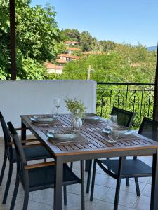 a wooden table and chairs on a balcony at Villagio Arcadia in Zátouna