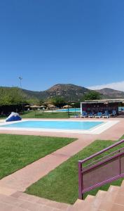 une piscine vide avec un bâtiment et des montagnes en arrière-plan dans l'établissement La Villa, Alojamiento Rural, à Iznájar