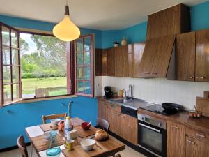 a kitchen with wooden cabinets and a wooden table with a tableablish at Villa Clair Soleil au cœur de la Toscane Occitane in Lisle-sur-Tarn