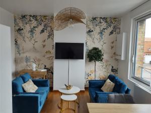 a living room with blue couches and a tv at Duplex Le Voltaire à 900m de la plage de Malo Les Bains in Dunkerque
