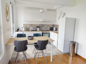 a kitchen with a wooden table and chairs at Duplex Le Voltaire à 900m de la plage de Malo Les Bains in Dunkerque