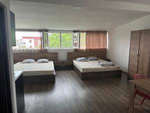 two beds in a room with two windows at BSG Rustaveli 184 in Kobuleti