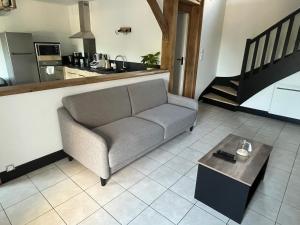 un salon avec un canapé et une table dans l'établissement La maison du bourg, à Candé-sur-Beuvron