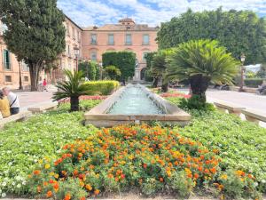 a fountain in a garden with flowers in front of a building at Céntrico Apartamento Vara de Rey in Murcia