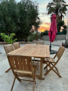a wooden table with two chairs and an umbrella at La maison du Soleil in Porticcio