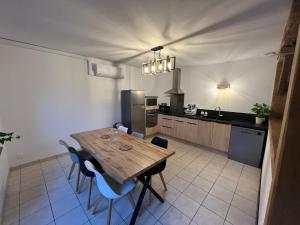 une cuisine avec une table en bois et des chaises bleues dans l'établissement La maison du bourg, à Candé-sur-Beuvron 4 autres photos