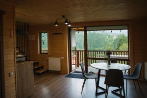 a room with a table and chairs and a balcony at Бриндуш in Tatariv