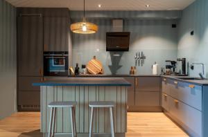 a kitchen with a blue counter and two bar stools at Modern Apartment close to Leknes in Leknes