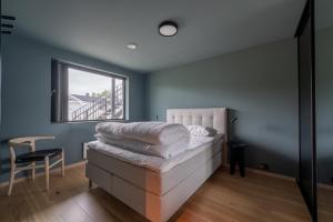 a bedroom with a bed with a window and a chair at Modern Apartment close to Leknes in Leknes