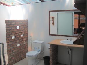 a bathroom with a toilet and a sink and a mirror at JJ Beach Resort & JJ Seafood in Ko Phayam