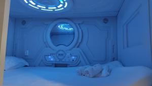 a blue room with a bed and a round window at min hostel reverencia in Madrid