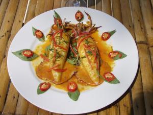 a white plate of food on a wooden table at JJ Beach Resort & JJ Seafood in Ko Phayam