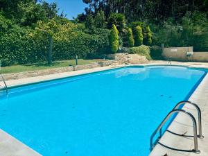 a large blue swimming pool with a chair next to it at Portosin Sea&Pool in Portosin