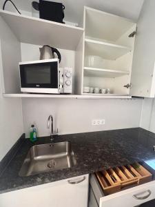 a kitchen with a sink and a microwave at Ferienwohnung "Seeluft" - Raus in die Berge und an den See in Schliersee