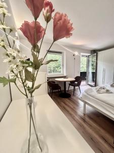 a vase with flowers on a table in a bedroom at Ferienwohnung "Seeluft" - Raus in die Berge und an den See in Schliersee