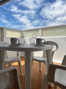 a table with chairs and glasses on a balcony at Garza Attic House in Ojos de Garza