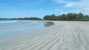 a beach with ripples in the sand and trees at JJ Beach Resort & JJ Seafood in Ko Phayam