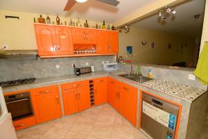 a kitchen with orange cabinets and a sink at vue sur la montagne in Pointe-Noire