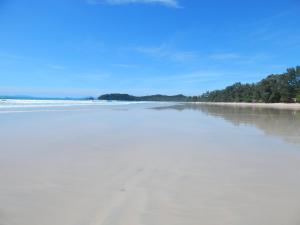 an empty beach with footprints in the sand at JJ Beach Resort & JJ Seafood in Ko Phayam