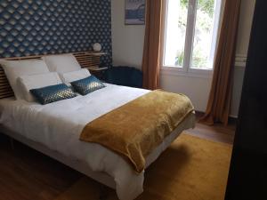 a bedroom with a bed with pillows and a window at Maison cosy citadine in Tours