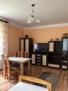a living room with a dining table and a tv at Leśniewscy - Pokoje Gościnne in Ojców