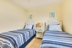 two beds sitting next to each other in a bedroom at Cute Cocoa Beach Condo with Pool and Beach Access! in Cocoa Beach +17 photos