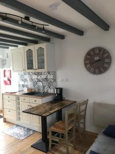 a kitchen with a table and a clock on the wall at La maison d'en face in Valliquerville