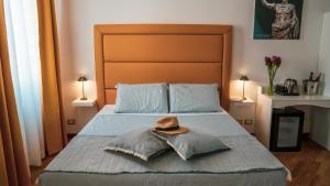 una camera da letto con un letto con un cappello sopra di TIBERIM Exclusive Rome a Roma Altre 28 foto
