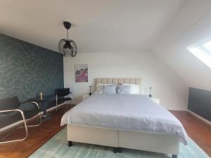 a bedroom with a large white bed and a chair at Duplex Apartment in Varsenare