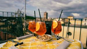 un tavolo con tre bicchieri da vino con dentro delle fette d'arancia di TIBERIM Exclusive Rome a Roma