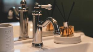 un lavandino in bagno con rubinetto d'argento su un bancone di TIBERIM Exclusive Rome a Roma