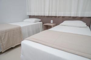 une chambre avec deux lits et une fenêtre dans l'établissement Lagoa Eco Towers - Apartamento para ate 7 pessoas com acesso a piscinas, quiosques, restaurante e muito mais, à Caldas Novas 24 autres photos