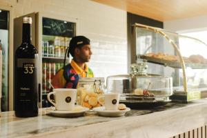 un homme debout derrière un comptoir avec une bouteille de vin dans l'établissement Lagoa Eco Towers - Apartamento para ate 7 pessoas com acesso a piscinas, quiosques, restaurante e muito mais, à Caldas Novas