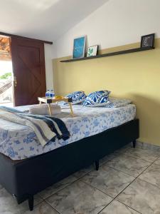 ein Bett mit blauen und weißen Kissen darauf in der Unterkunft Apartamento Sol Nascente no centro da cidade in Cruz das Almas + 13 Fotos