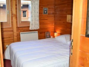 エム・ラ・プラーニュにあるChalet Boulevard - Chalet Boulevard -8 pers - PLAGNE CENTRE, sur les pistes - wifi - CTBOU MAE-6814の木製の壁のベッドルーム1室(白いベッド1台付)