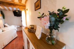 a vase of flowers on a table in a living room at Gîte Saint Amour in Le Pin