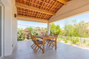an outdoor patio with a wooden table and chairs at Villa Thym in Marignane