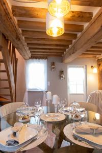 a dining room with a glass table and chairs at Gîte Saint Amour in Le Pin +15 photos