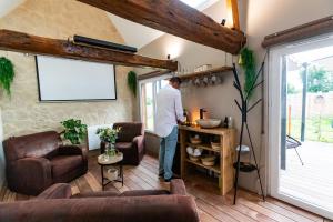 a man standing at a bar in a living room at Gîte Saint Amour in Le Pin
