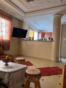 a living room with a table and a tv at SINIM HOUSE in Taghazout