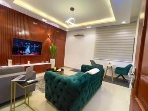 a living room with a green couch and a tv at Luxe à Fidjrosse in Cadjèhoun