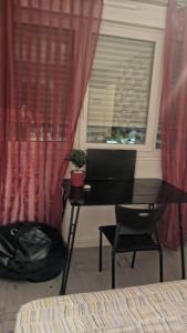a desk with a laptop on it in front of a window at Apartamento de ferias in Bezons