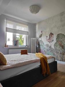 a bedroom with a bed with a bird mural on the wall at Apartament przy stadionie miejsce parkingowe in Gorzów Wielkopolski
