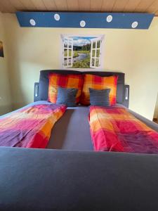 a bedroom with two beds with colorful sheets at Roomfortwo Natural in Waldsolms +30 photos
