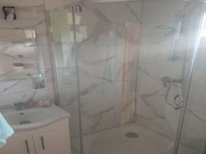 a bathroom with a shower and a sink at Domki letniskowe OSTROWITE in Ostrowite