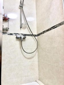 a shower with a hose in a bathroom at Creteil new 1 in Créteil