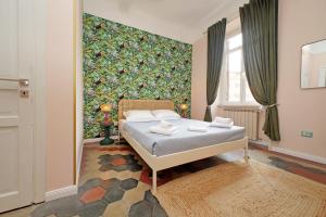 a bedroom with a bed and a large wall at Colosseo Kokedama rooms in Rome
