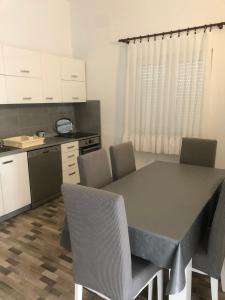 a kitchen with a table and chairs in a room at Very spacious - fully air conditioned - apartment nearby Vir bus station in Vir
