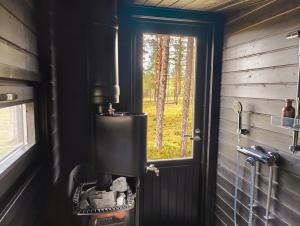 アカスロンポロにあるLapland Riverside Cabin 4 HILLA , Ylläs, Tiny Home with Sauna, Fireplace, Terrace, BBQ, Wifi, Ski, Fishing, Pets OKの窓付きの客室内の小さなコンロ